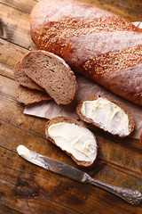 Fresh bread and homemade butter on wooden background