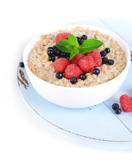 Tasty oatmeal with berries isolated on white