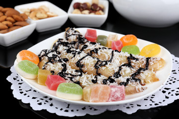 Sweetened fried banana on plate on black background, close-up