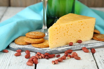 Wine, cheese and crackers on wooden table close-up