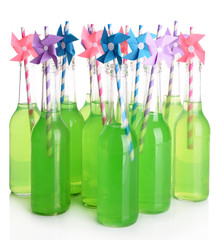 Bottles of drink with straw on light background