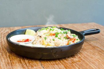 hot fried rice on wooden table serve on black pan