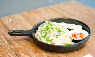 hot fried rice on wooden table serve on black pan