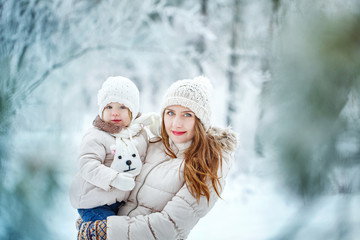 Fototapeta na wymiar Mother holds daughter on hands in winter forest