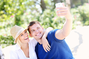 Young couple taking a picture of themselves at the beach