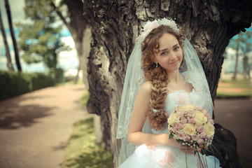 Portrait of beautiful bride in a park