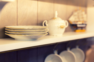 Fototapeta na wymiar White plates and dinnerware in a cupboard