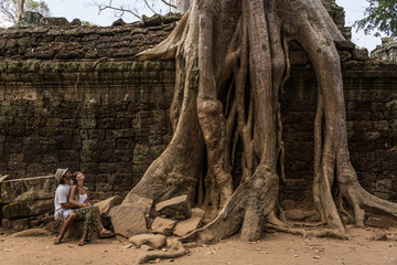 Obraz premium Beautiful Couple looking at Giant Roots at Angkor Wat Cambodia.