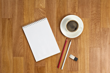 Obraz na płótnie Canvas Blank notepad with office supplies and cup of coffee on wooden t
