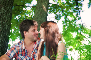 Fototapeta premium Smiling couple resting near a tree