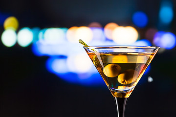 glass with martini and green olives