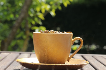 goldfarbene Kaffeetasse auf Holztisch