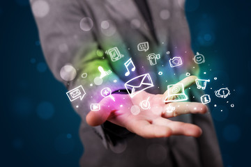 Young businessman presenting colorful glowing social media icons