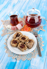 Sweet baklava on plate with tea on table