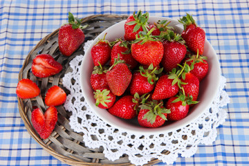 Strawberries in plate on wicker stand on napkin