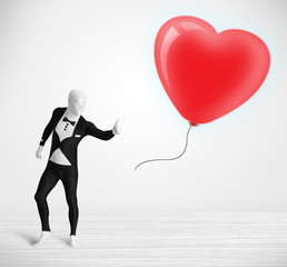 Cute guy in morpsuit body suit looking at a balloon shaped heart
