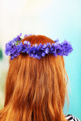 Naklejka premium Fresh cornflower wreath on female head on light background