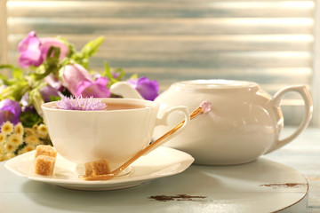 Cup of fresh herbal tea on table