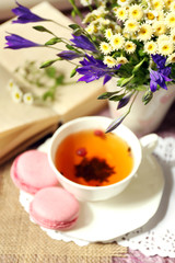 Cup of fresh herbal tea on table