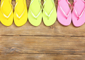 Bright flip flops on wooden background