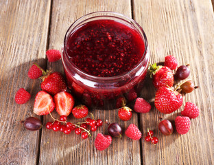 Berries jam in glass jar on table, close-up
