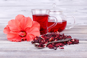 Hibiscus tea in glass teapot and flower