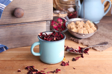 Obraz na płótnie Canvas Dried hibiscus tea in color mug, brown sugar in box