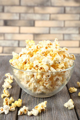 Popcorn in bowl on wooden table, close up