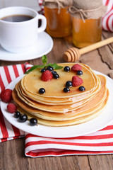Sweet pancakes with berries on table close-up