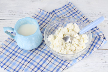 Cup of milk and cottage cheese in glass bowl
