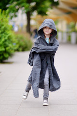 Funny little girl wearing her fathers' coat