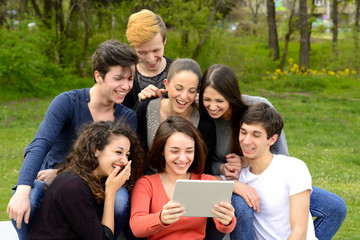 Group of young adults browsing a tablet outside