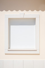 White shutter on a window in the sunshine