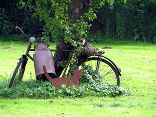 altes rostiges antikes Fahrrad lehnt an Baum