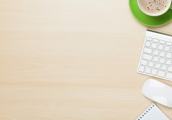 Office table with notepad, computer and coffee cup