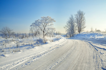 winter landscape with the road, forest and the blue sky