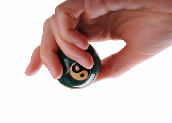 woman hand holding a ball with ying and yang symbols