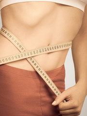 Weight loss, measuring tape on woman waistline