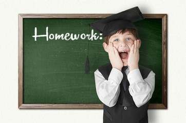 Cheerful little boy on blackboard. Looking at camera