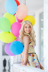 Fototapeta na wymiar A young woman with large colourful latex balloons
