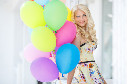 A young woman with large colourful latex balloons