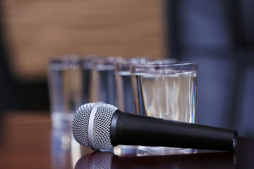 Obraz premium Microphone with glasses of water on table close-up