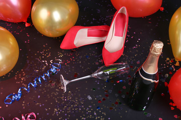 Shoes with confetti, champagne and balloons on the floor