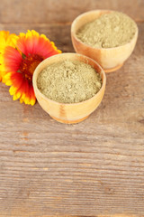 Dry henna powder in bowls on wooden table