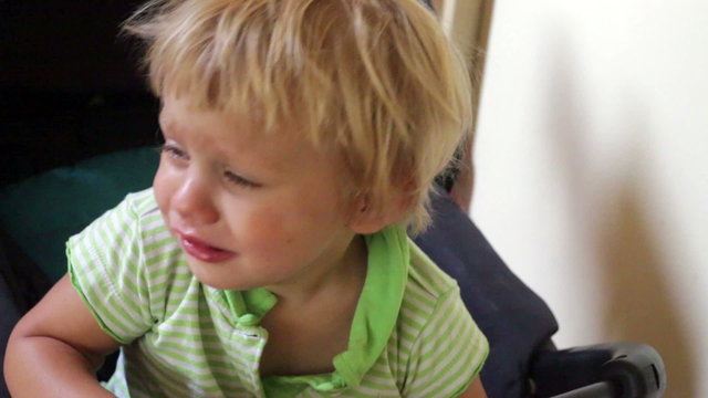Crying two year old child in a buggy