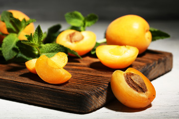 Ripe apricots with green mint leaves