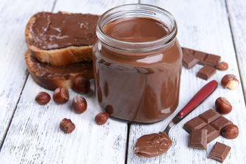 Sweet chocolate cream in jar on table close-up