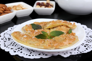 Sweetened fried banana on plate on black background, close-up