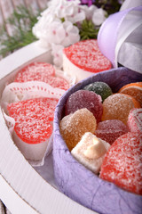 Present box with sweets and flowers close up