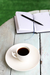 Cup of coffee on wooden table, outdoors